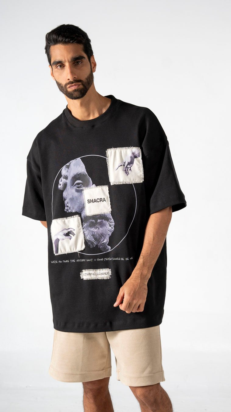 Black graphic oversized t-shirt with surreal art patches, vintage Aesthetic, casual streetwear, men's fashion, unique style, Shacra clothing brand.