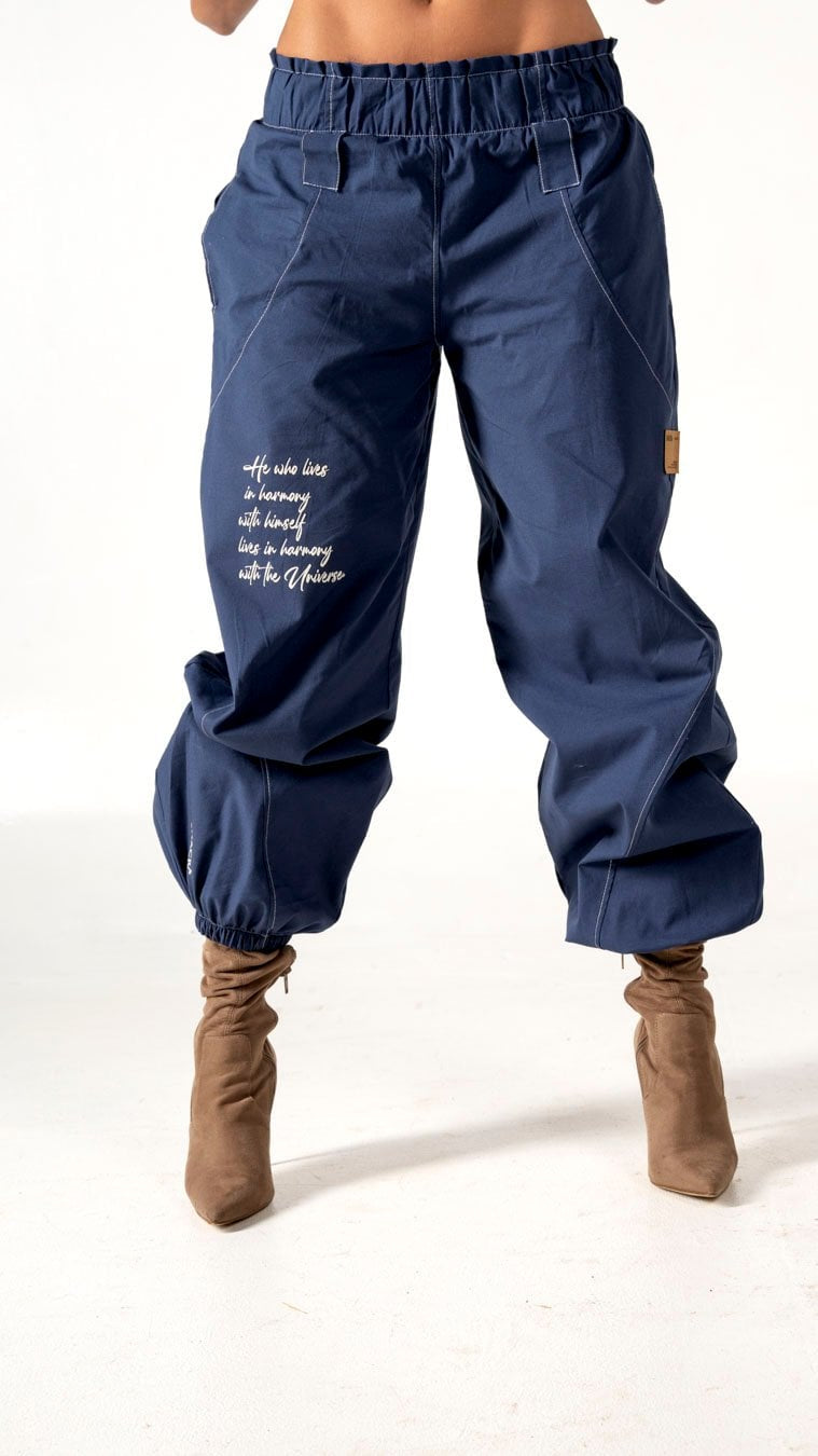 Relaxed fit navy blue cargo pants with inspirational embroidery, elastic waistband, and ankle cuffs, perfect for casual wear or street style outfits.