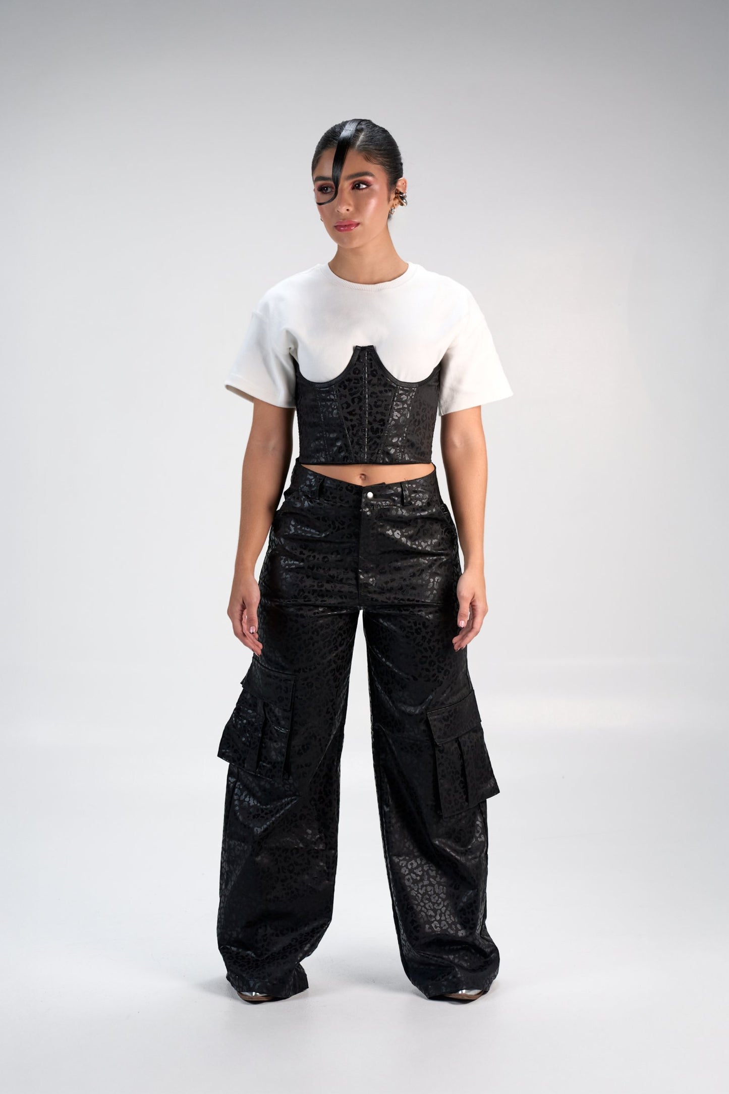 Floral black corset top paired with black cargo wide-leg pants, streetwear fashion, modern edgy style, trendy women's clothing, fashion photo shoot, casual yet chic, contemporary outfit, stylish attire, urban fashion look, urban fashion style.