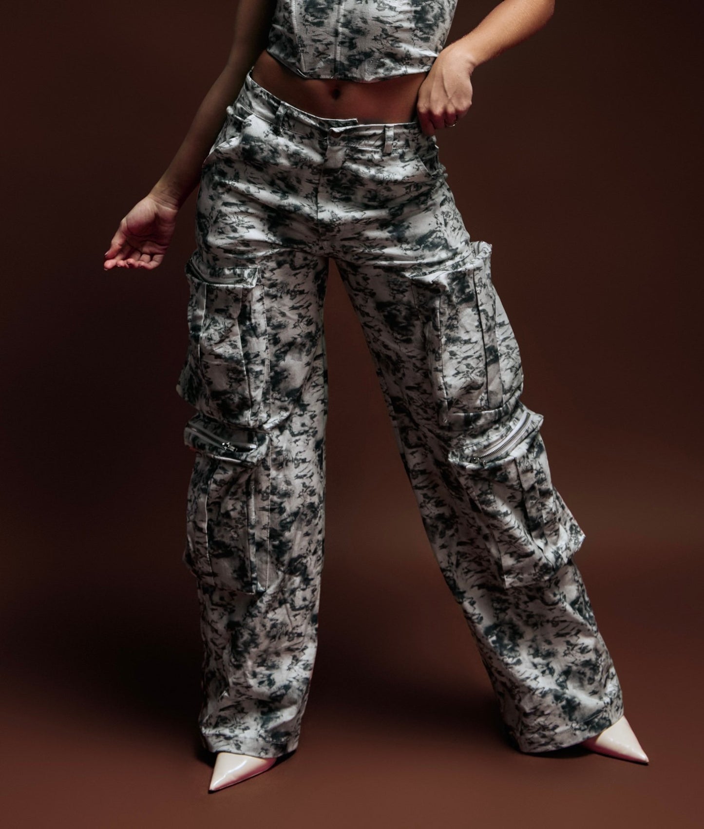 Bold camouflage cargo pants and a stylish matching top, emphasizing trendy streetwear fashion for women featuring oversized pockets and zippers. Perfect for modern casual and urban outfits.