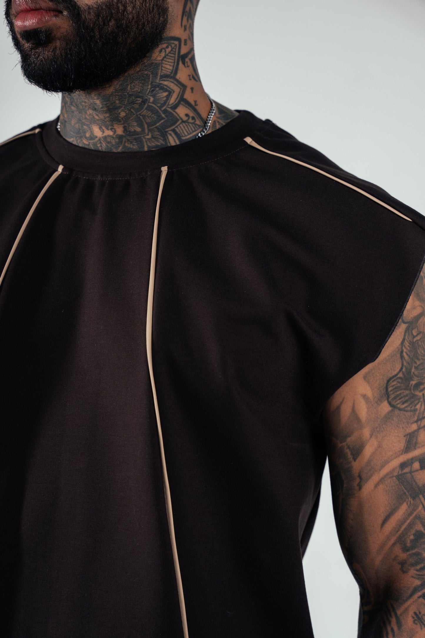 Luxury black designer tank top with beige piping, modern streetwear style, comfortable fit, high-quality fabric, trendy athletic fashion, sleeveless men's top, fashionable sportswear, stylish casual wear, Shacra brand.