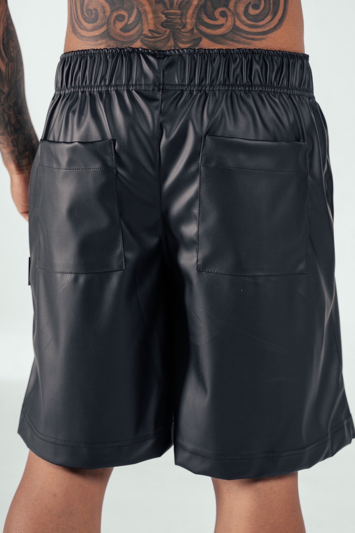 Sustainable faux leather shorts with an elastic waistband and pocket details, perfect for stylish casual wear and fashion-forward styling.