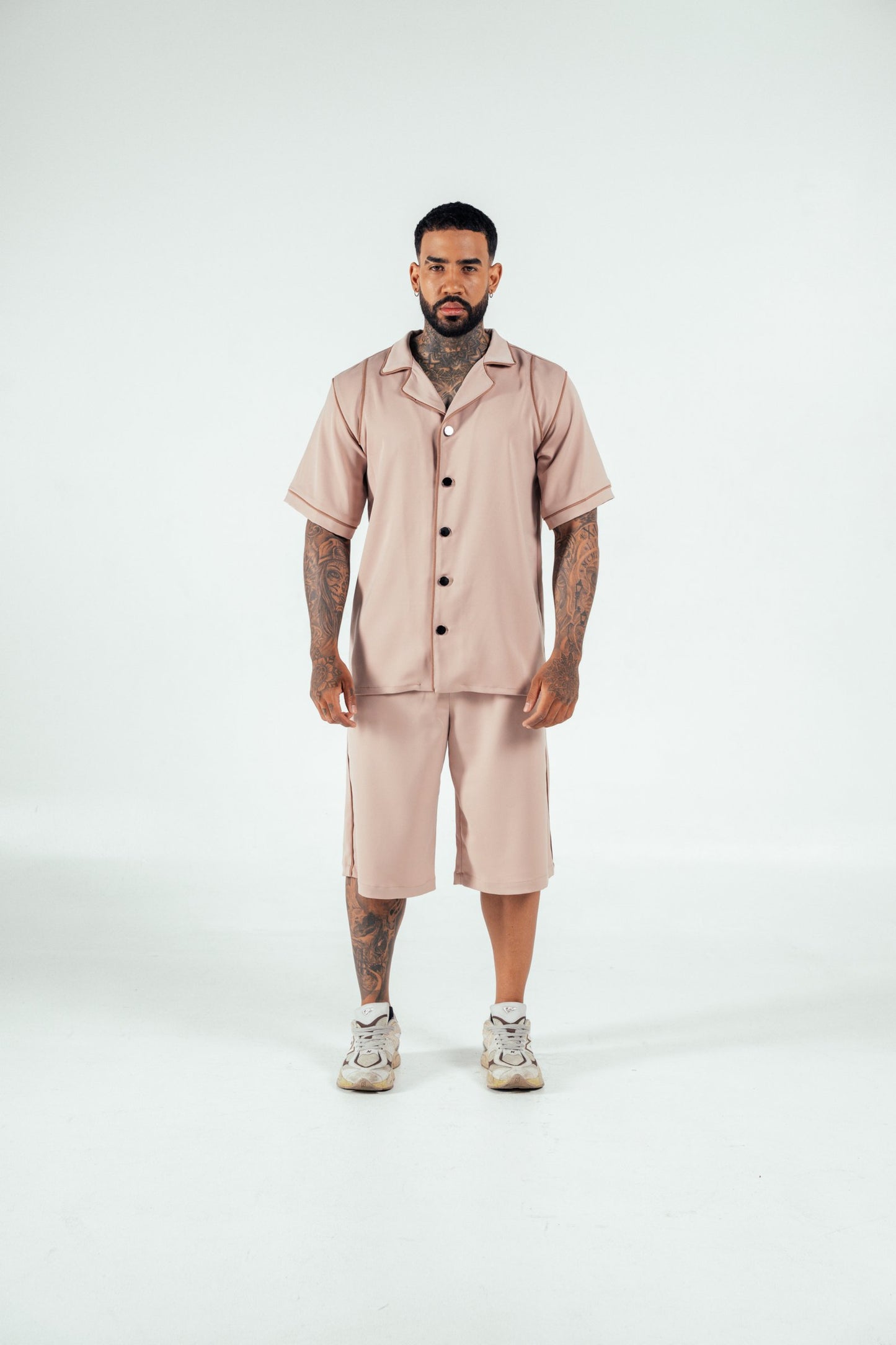 Comfortable beige satin loungewear set with short-sleeve shirt and knee-length shorts, perfect for casual wear or relaxing at home. Stylish and trendy, designed for modern comfort.