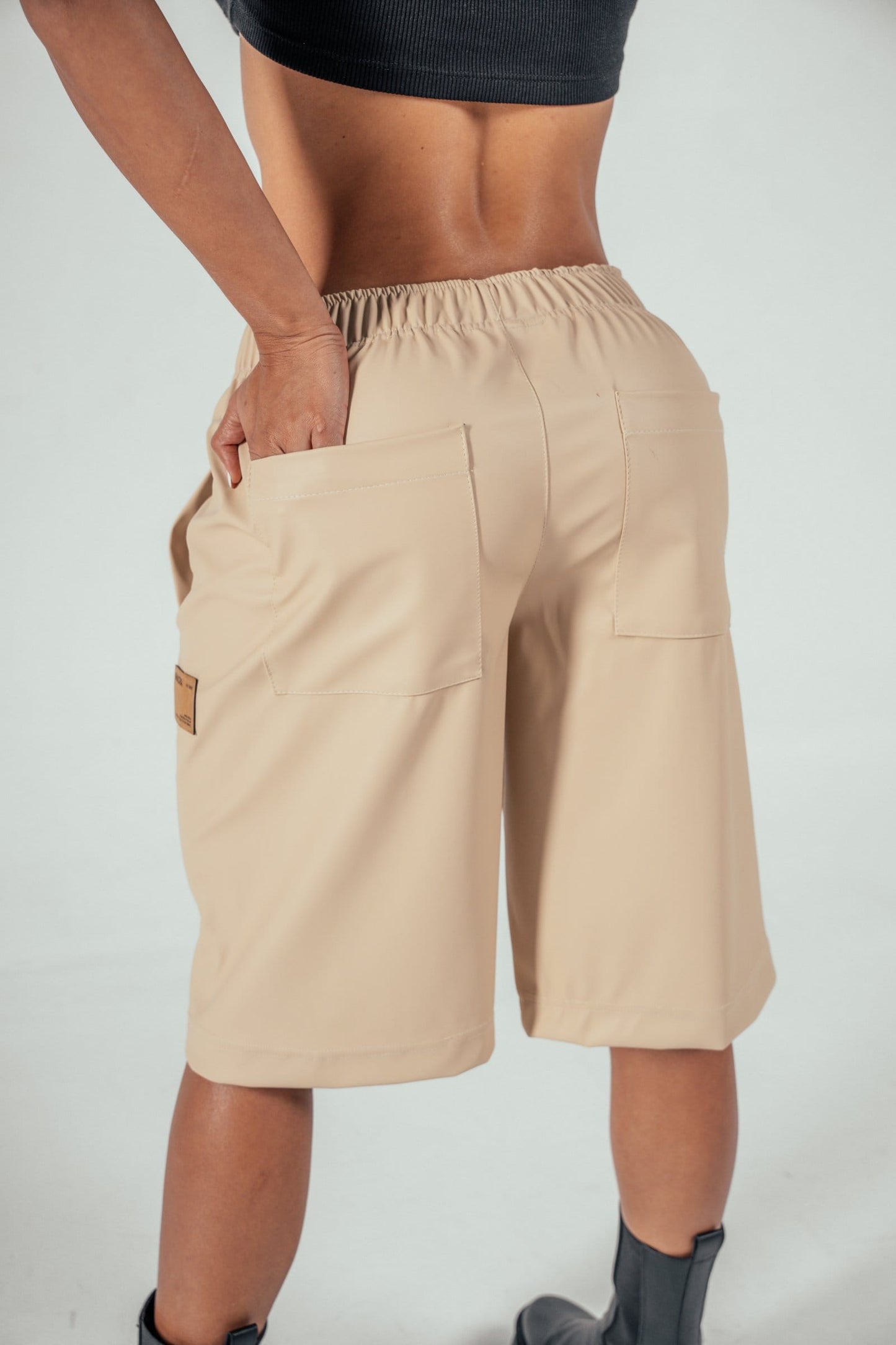 Beige wide-leg casual shorts with elastic waistband and large back pockets, stylish comfortable summer clothing for women made from lightweight fabric, perfect for everyday wear and outdoor activities.