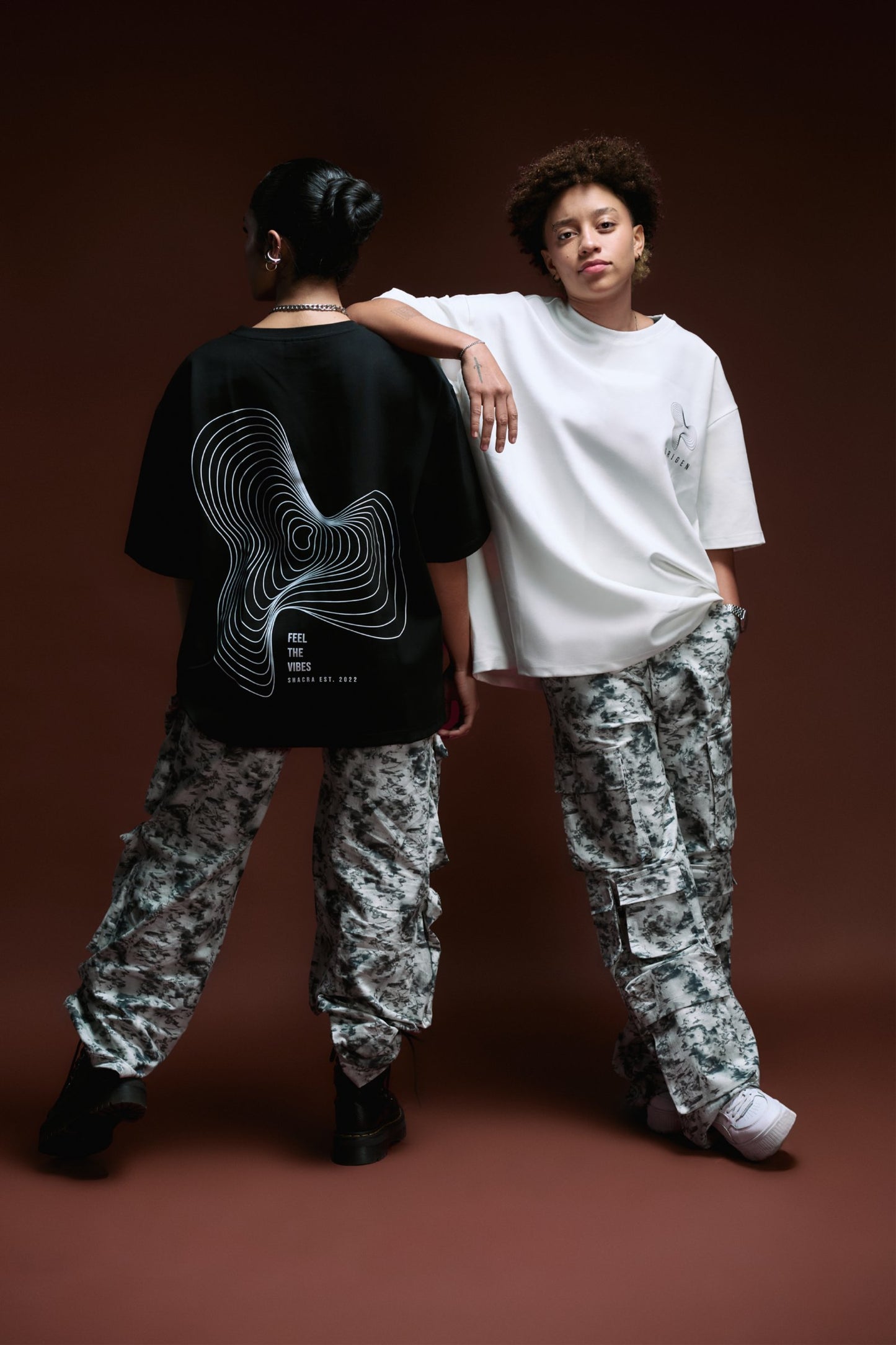 Black and white casual streetwear outfits featuring graphic t-shirts with artistic designs, camouflage cargo pants, and stylish sneakers, embodying modern fashion for confident, expressive individuals.