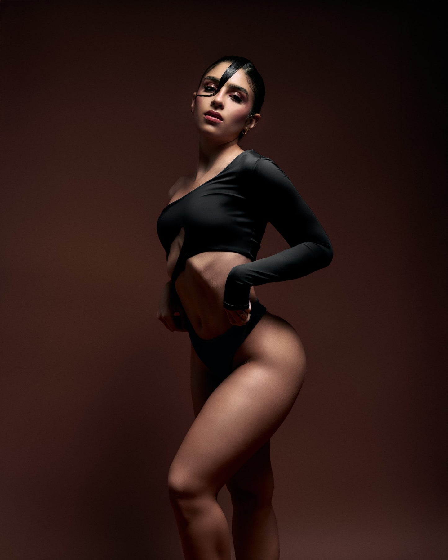 Elegant woman in black cut-out fashion photoshoot, highlighting modern body positivity and confidence. Perfect for fashion, glamour, and contemporary style inspiration.