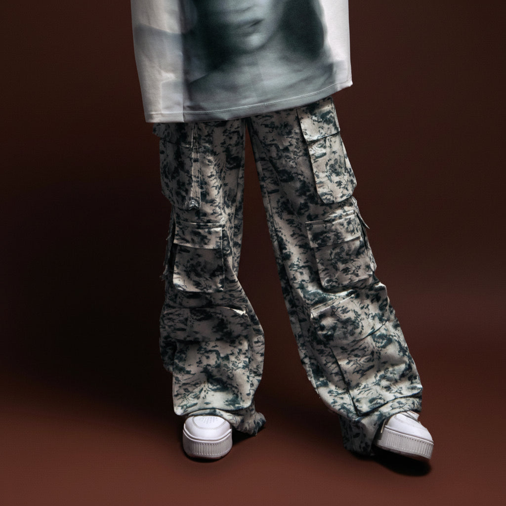 Cargo pants with a black and white camouflage pattern and chunky white sneakers, styled for a streetwear look.