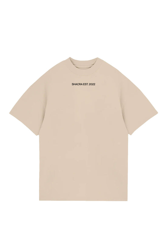 Beige oversized t-shirt with black "SHACRA EST. 2022" text on the chest, casual streetwear design perfect for everyday style.