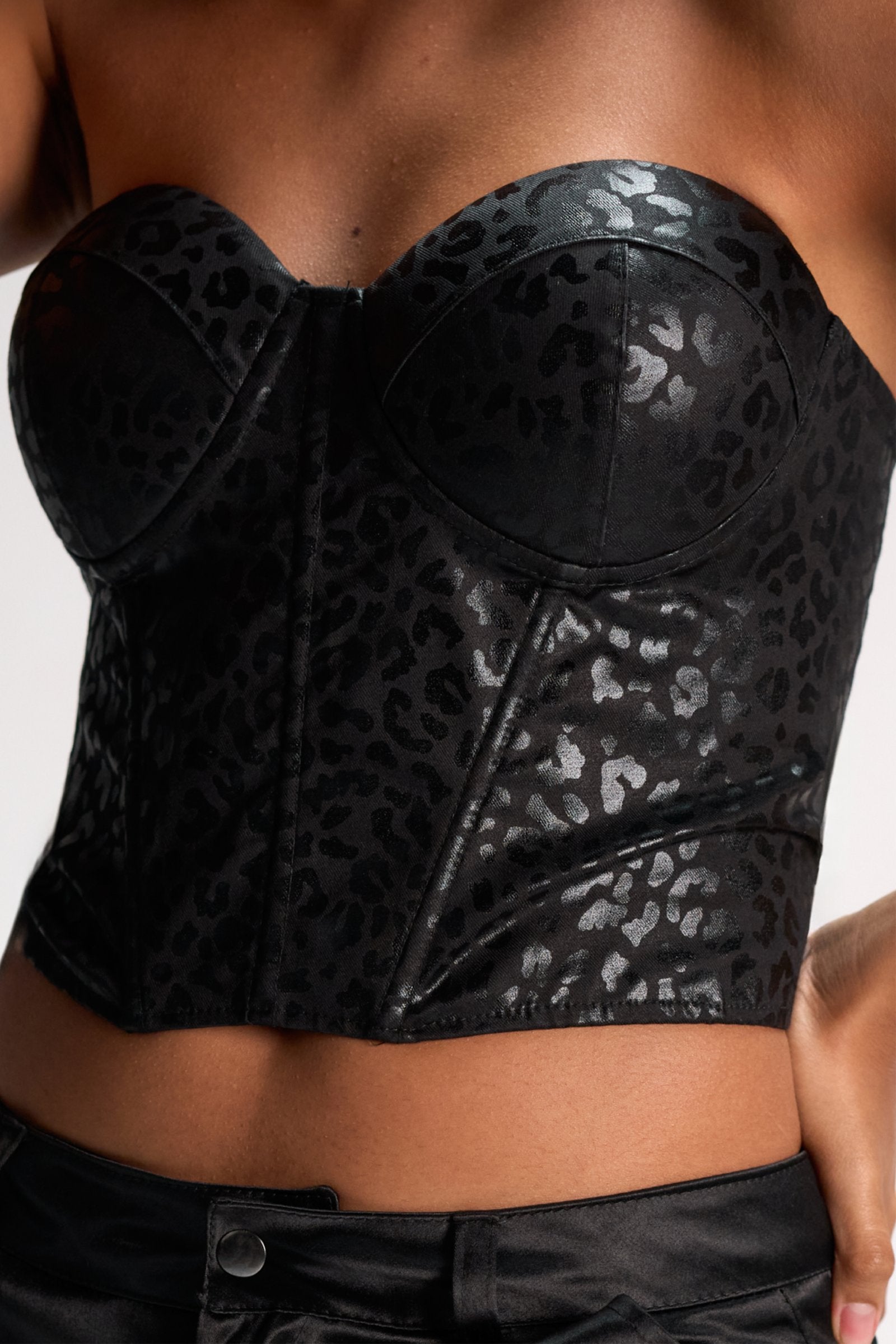 Leopard print black leather bustier top emphasizing stylish, trendy women's fashion for a bold, chic look. Perfect for enhancing curves and making a statement.