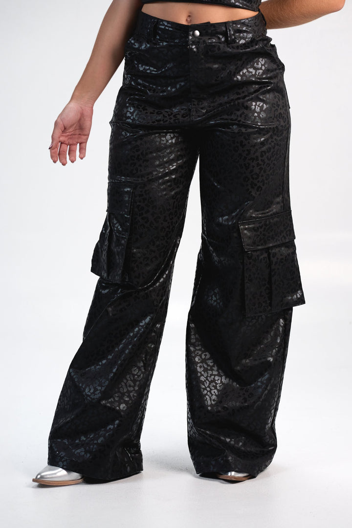 Leopard print black cargo pants with shiny finish, relaxed fit, featuring large side pockets, perfect for fashion-forward, casual, streetwear style.