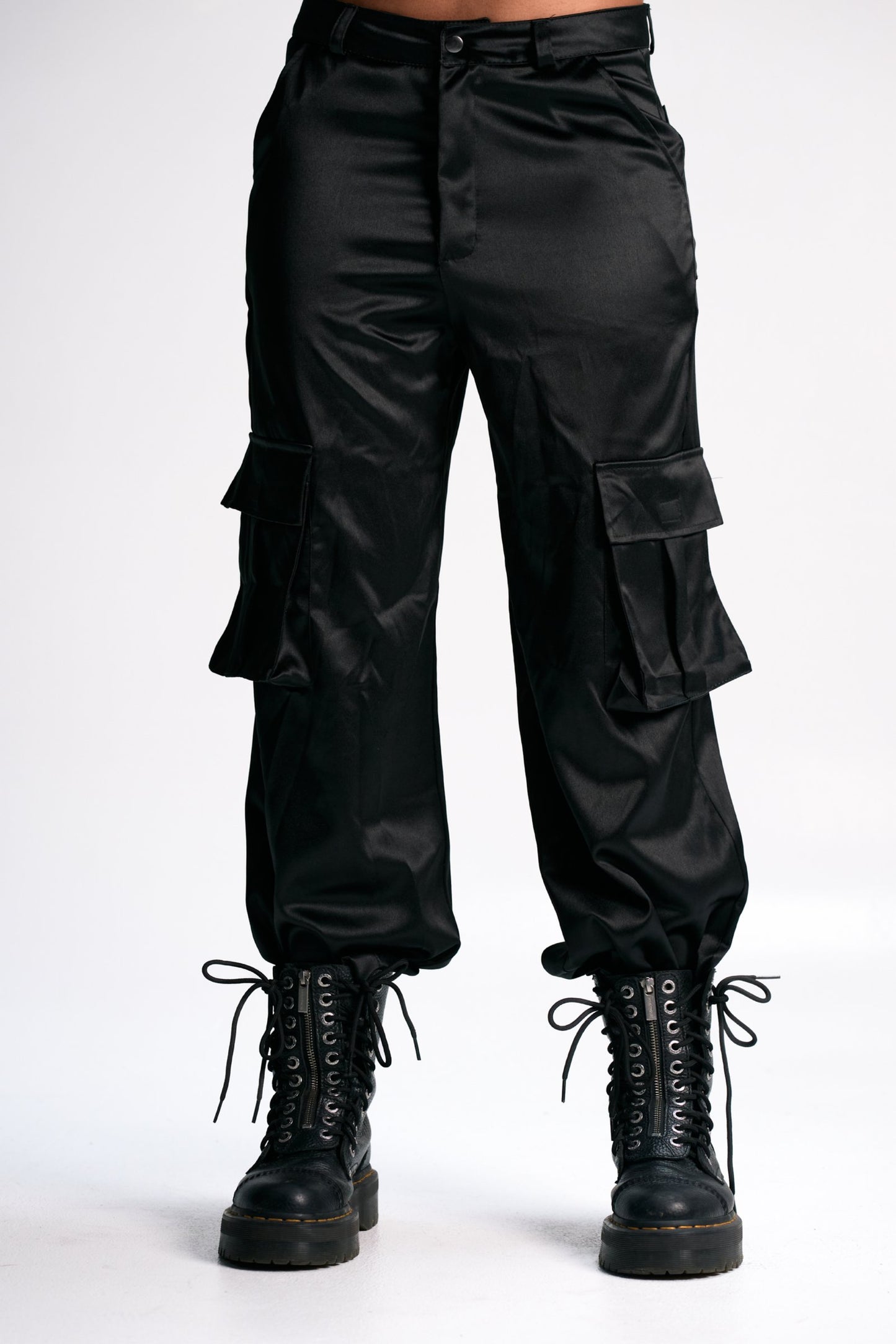 Cargo pants with lace-up combat boots in black satin fabric, stylish and trendy streetwear ensemble. Perfect for casual, edgy fashion looks.