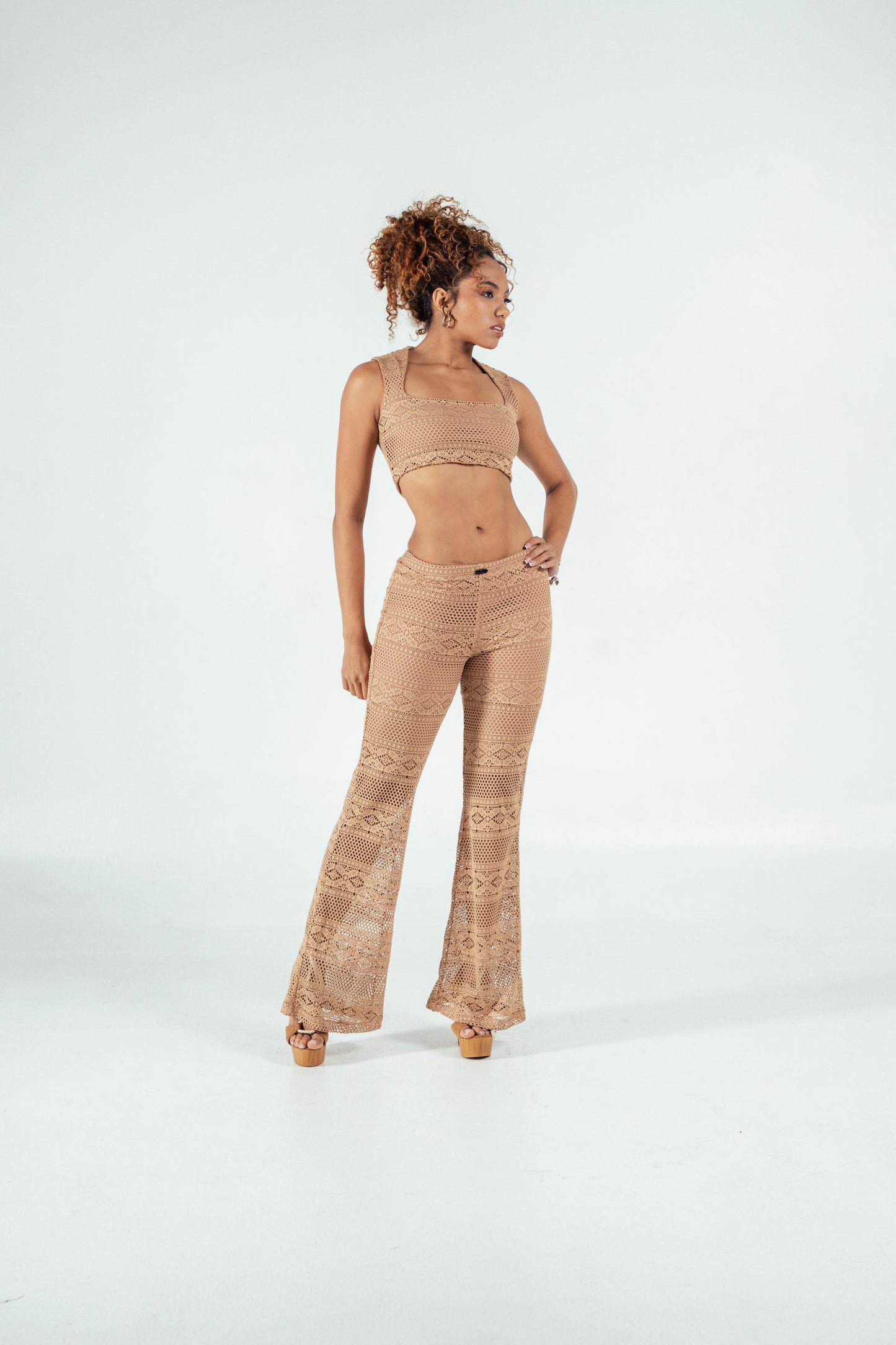 Luxury boho crochet two-piece outfit for women, featuring a crop top and high-waisted flared pants, perfect for summer festivals and beach days, by Shacra.
