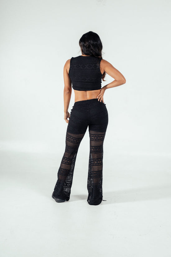 Black lace crochet two-piece outfit featuring a sleeveless crop top and wide-leg pants, perfect for trendy, stylish summer or beachwear looks.