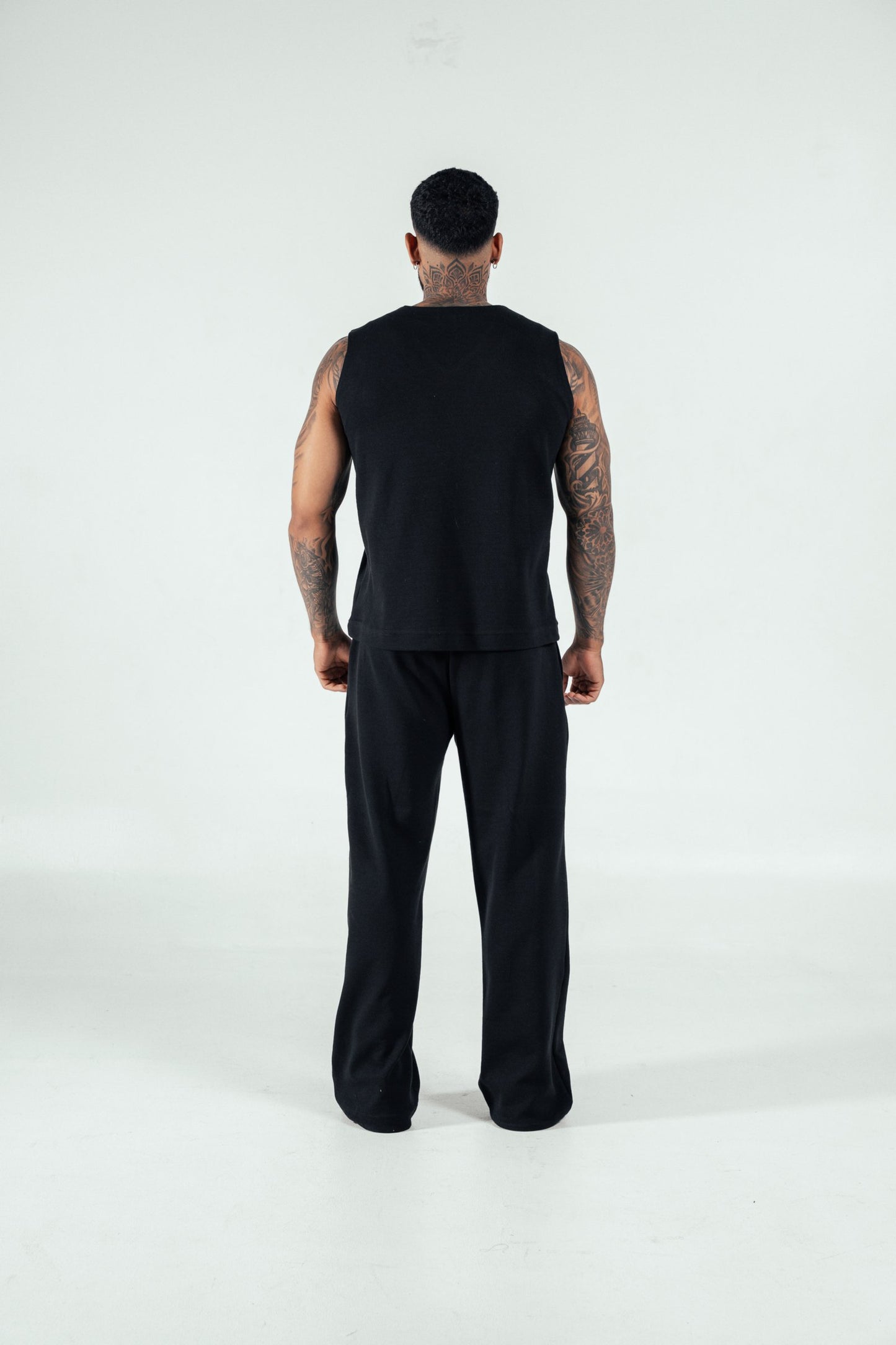 Sleek black sleeveless tank top paired with comfortable black pants, perfect for modern casual and athletic wear. Looks stylish and versatile for active lifestyles.