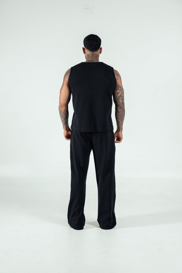 Sleek black sleeveless tank top paired with comfortable black pants, perfect for modern casual and athletic wear. Looks stylish and versatile for active lifestyles.
