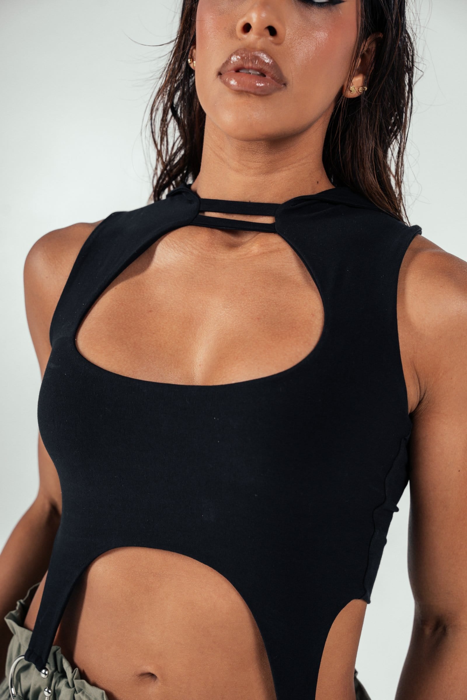 Black cut-out halter top with unique strap design, trendy fashion piece by Shacra, perfect for modern stylish women, close-up shot emphasizing neckline and fabric detail.