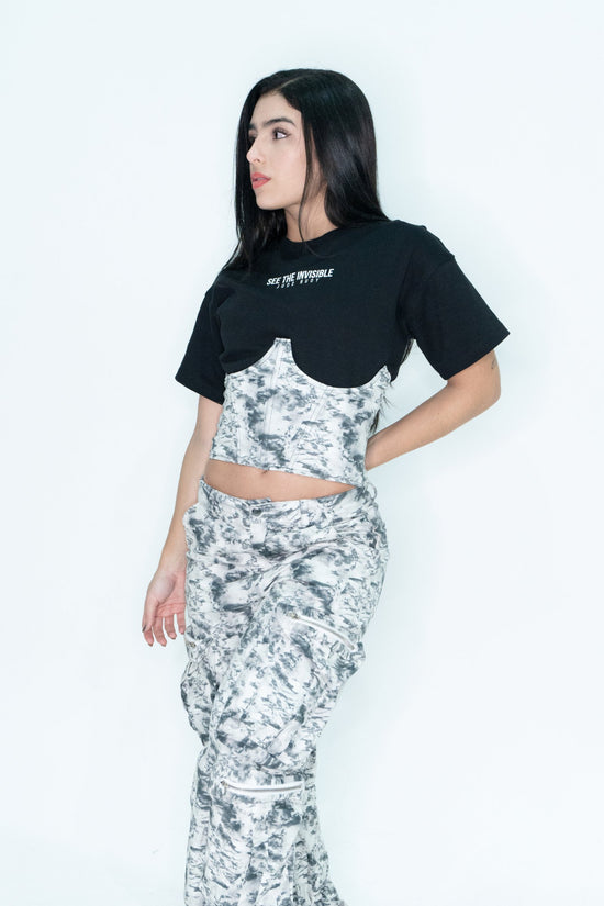 Black graphic t-shirt with "See the Invisible" slogan paired with tie-dye cargo pants, perfect for stylish streetwear and casual fashion statements.