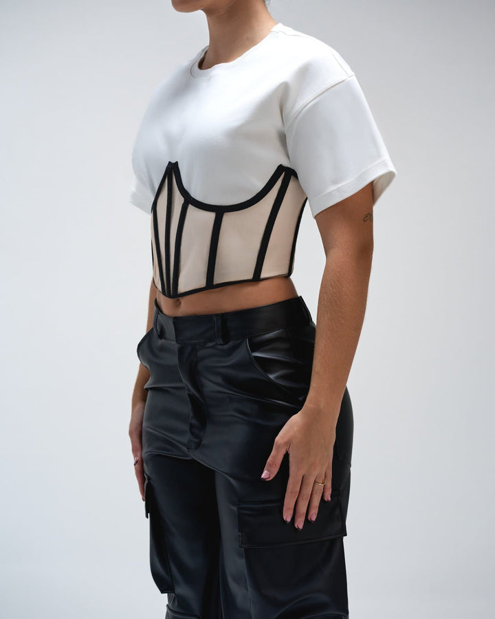 Modern black leather cargo pants with stylish design and multiple pockets, paired with a unique cropped white T-shirt with black piping accents for trendy streetwear fashion.