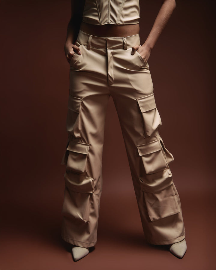 High-waisted beige cargo pants with multiple pockets, styled for a modern fashion look. Perfect for streetwear and casual outfits, showcasing trendy and versatile clothing by Shacra.