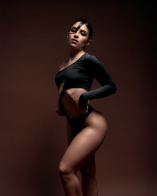 Elegant woman in black cut-out fashion photoshoot, highlighting modern body positivity and confidence. Perfect for fashion, glamour, and contemporary style inspiration.