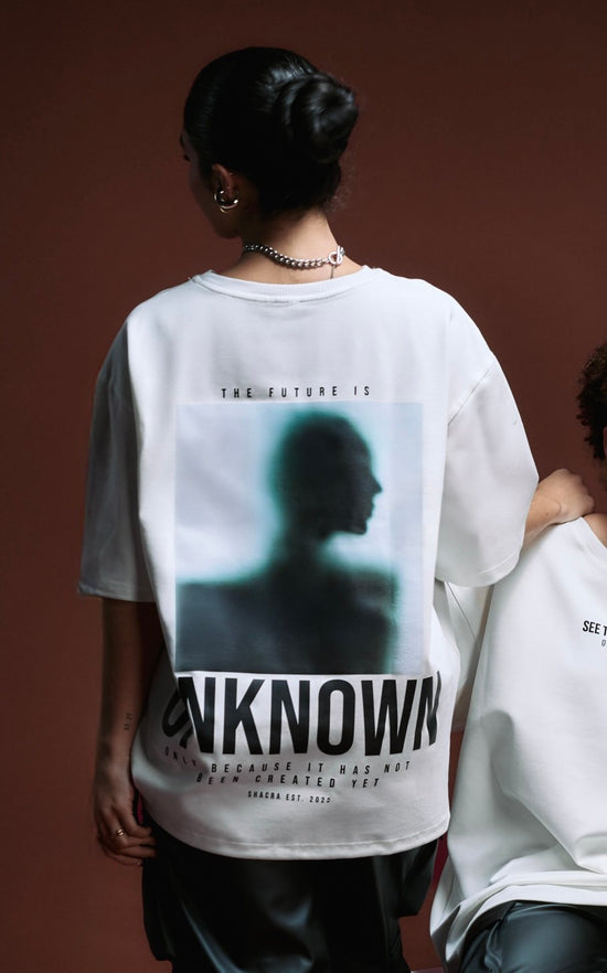 Abstract image of a woman wearing a white graphic t-shirt with modern art and philosophical text, emphasizing contemporary streetwear fashion and artistic photography.