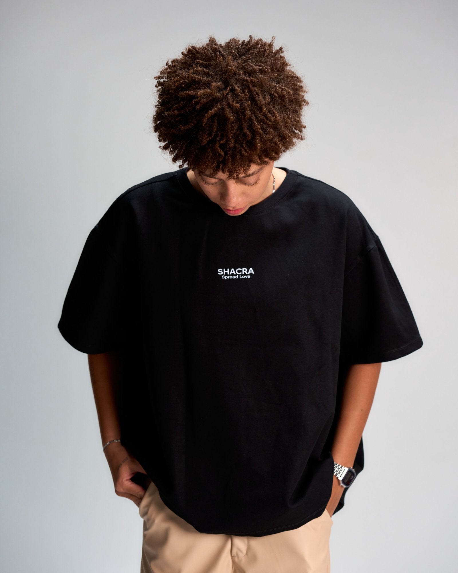 Bold Black T-shirt with "SHACRA Spread Love" logo, casual streetwear style featuring relaxed fit, short sleeves, and minimalistic design. Perfect for modern fashion statements and everyday comfort.