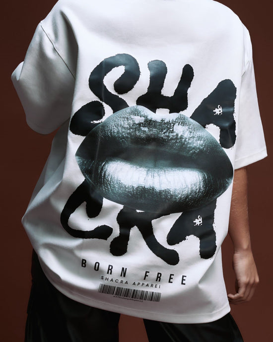 Bold graphic white T-shirt featuring a large black lip print and the word "SHACRA" in stylized font, part of the trendy Shacra apparel collection, perfect for streetwear and fashion-forward looks.