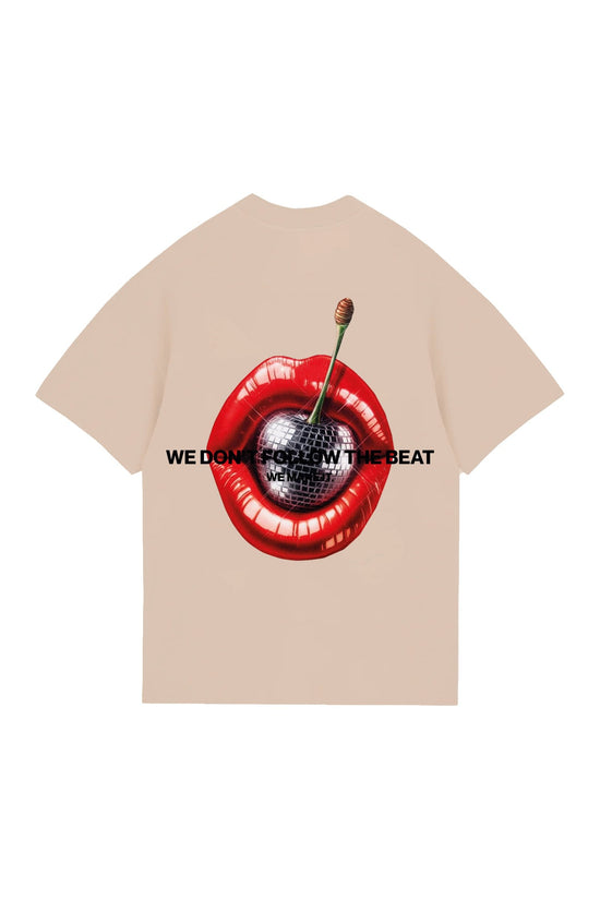 Vivid graphic t-shirt featuring a red lips design with a cherry and disco ball, with the phrase "We don't follow the beat, we make it," ideal for bold fashion statements.