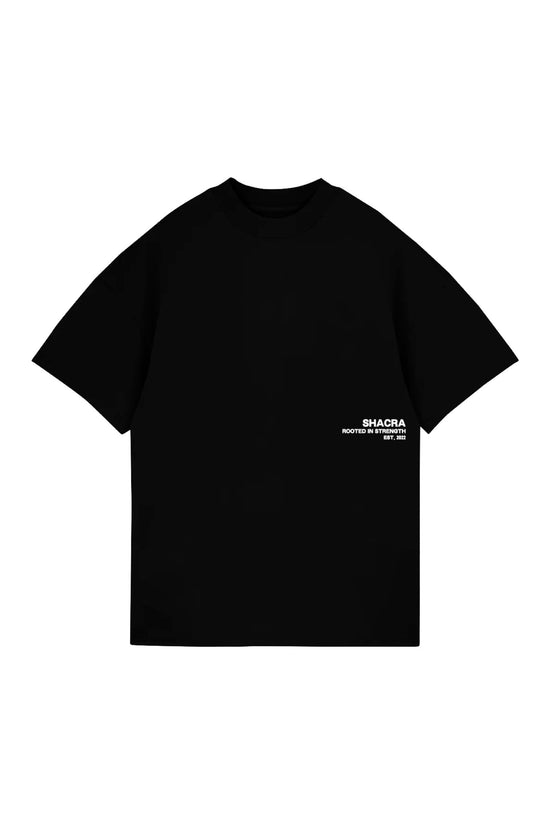 Black T-shirt with "SHACRA rooted in strength EST. 2022" printed in white on the lower right side, representing modern streetwear fashion and urban style.