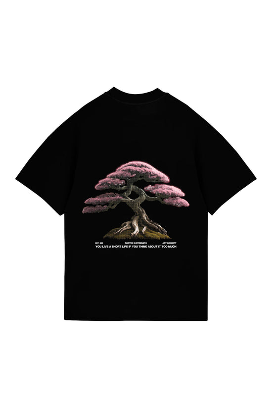 Vibrant black T-shirt featuring a detailed pink cherry blossom tree design, symbolizing strength and resilience, with inspirational quote for personal growth and mindfulness. Perfect for streetwear and art enthusiasts.