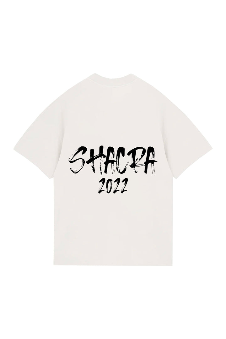 Black distressed text reading "SHACRA 2022" on a white T-shirt, showcasing custom graphic apparel design, stylish and trendy for modern fashion enthusiasts.