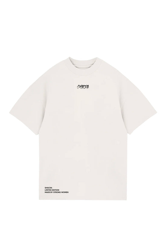 Bold white T-shirt with "SHACRA" logo in black text, oversized fit, made for women, reflecting strength and limited edition style from Shacra.