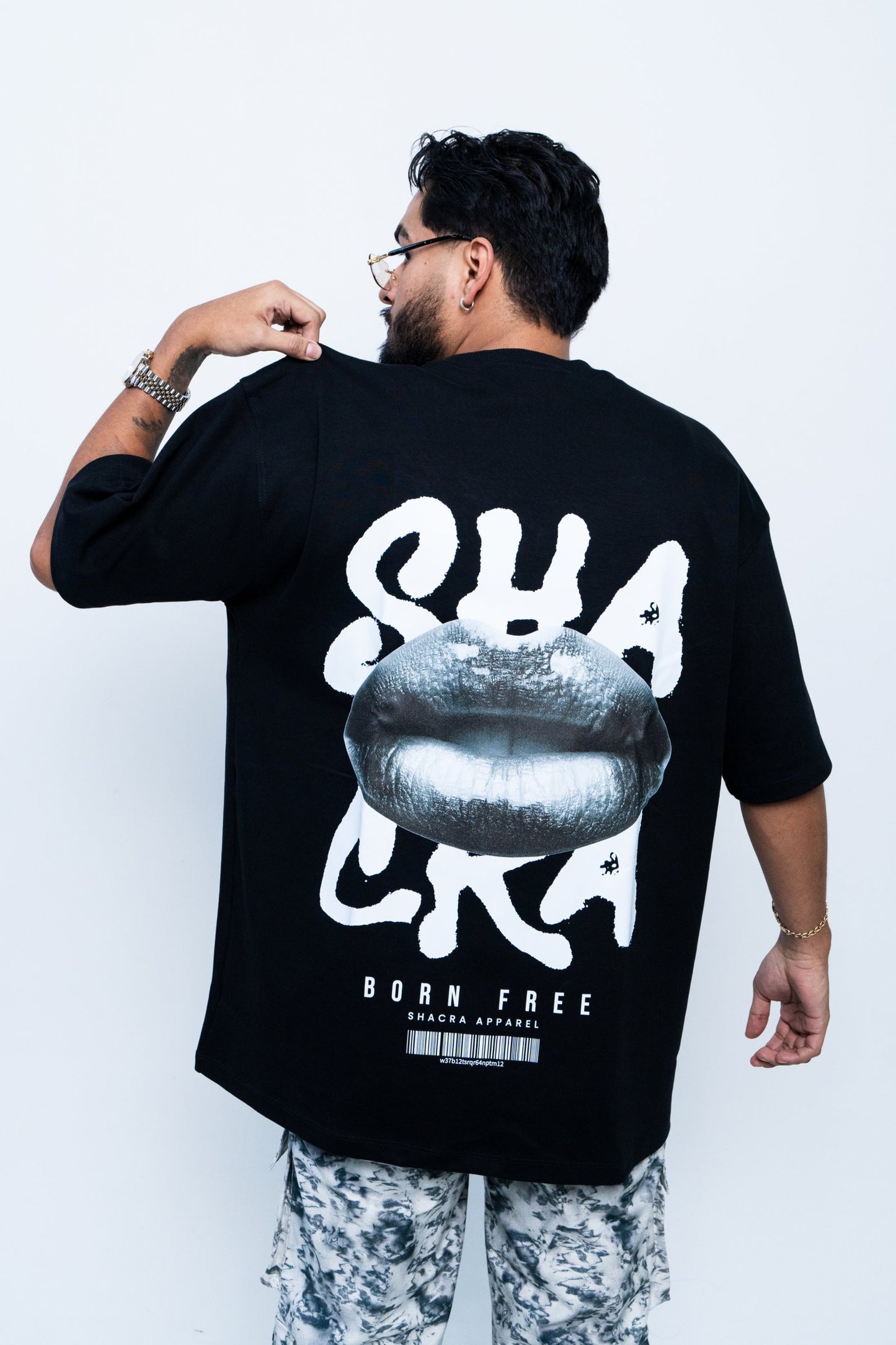 Black graphic T-shirt with a large silver lipstick print and bold white text that says "SHACRA", styled for streetwear fashion.