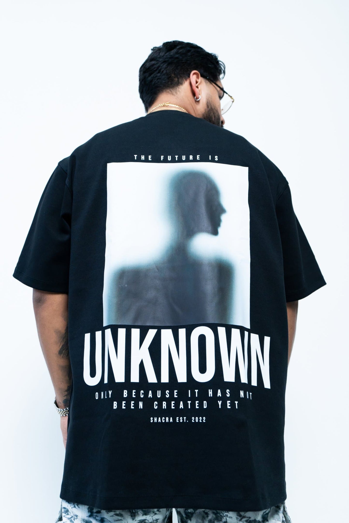 Unisex graphic T-shirt featuring a blurred silhouette of a woman with bold text "UNKNOWN" and fashion-forward design, perfect for streetwear and edgy fashion styles.