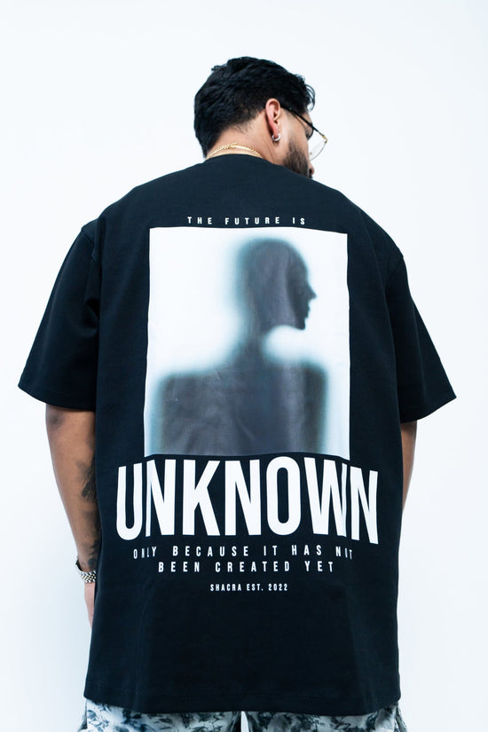 Unisex graphic T-shirt featuring a blurred silhouette of a woman with bold text "UNKNOWN" and fashion-forward design, perfect for streetwear and edgy fashion styles.